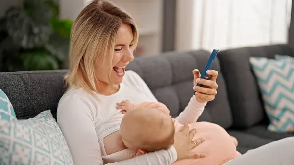 Mother Daughter Sitting Sofa Breastfeeding Baby Using Smartphone Home — Stock Photo, Image