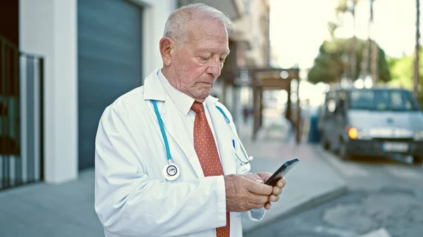 Senior Doctor Canoso Pie Con Expresión Seria Usando Smartphone Calle — Foto de Stock