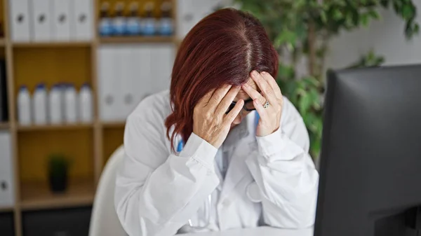 Middle age woman doctor stressed working at the clinic