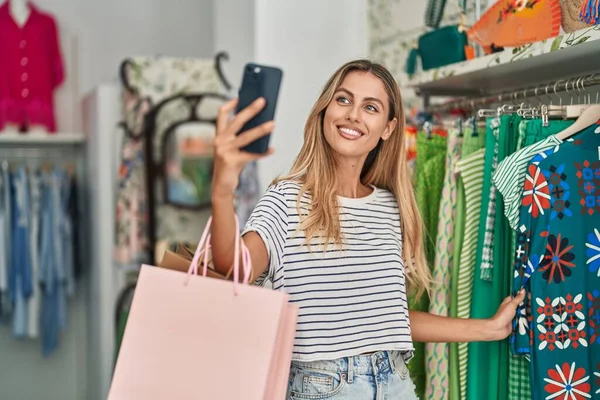 Young blonde woman customer smiling confident make selfie by smartphone at clothing store