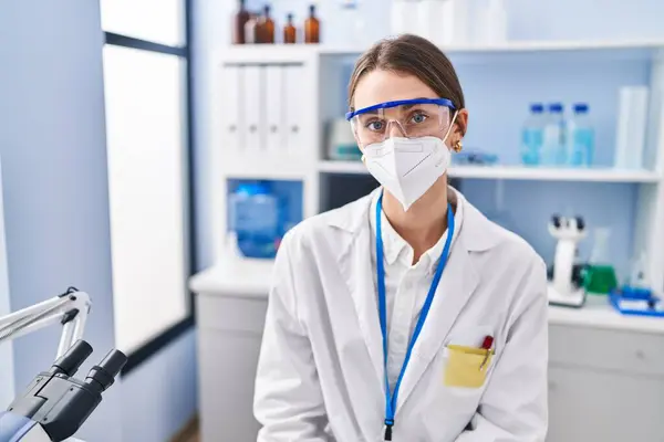 Νεαρή Καυκάσια Επιστήμονας Που Φοράει Ιατρική Μάσκα Στο Εργαστήριο — Φωτογραφία Αρχείου
