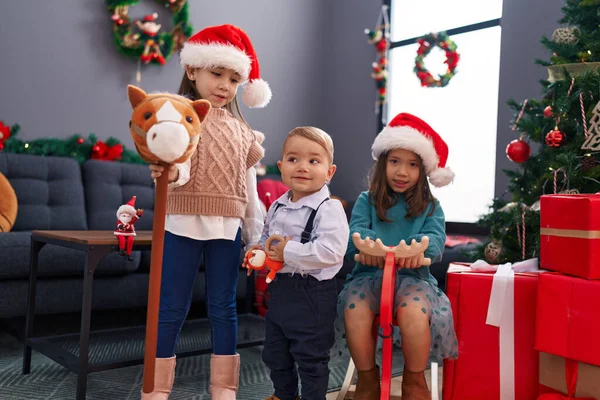 一群孩子在家里的圣诞树旁玩驯鹿摇椅和马玩具 — 图库照片