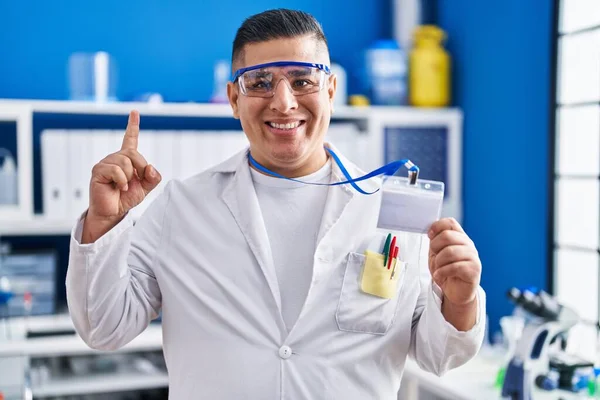 Hispanic Young Man Working Scientist Laboratory Holding Card Smiling Idea — Stock Photo, Image