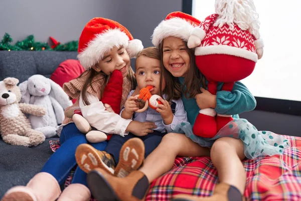 Grupa Dzieci Przytula Się Siedząc Kanapie Przez Świąteczne Dekoracje Domu — Zdjęcie stockowe