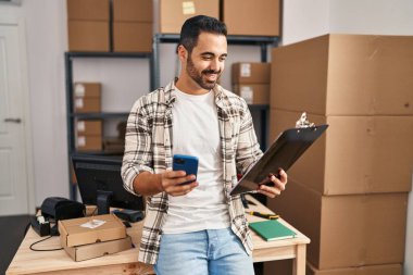 Genç bir İspanyol iş adamı ofisteki akıllı telefon okuma belgesini kullanıyor.