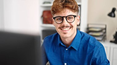 Ofiste gülümseyen bilgisayar kullanan İspanyol bir iş adamı.