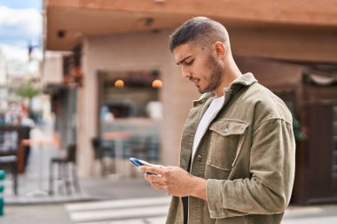 Sokakta akıllı telefon kullanan genç bir İspanyol.