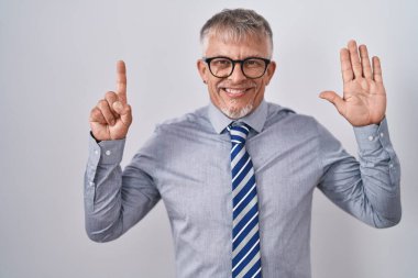 İspanyol iş adamı, gri saçlı, gözlüklü, altı numaralı parmaklarıyla işaret eden, kendinden emin ve mutlu gülümseyen.. 