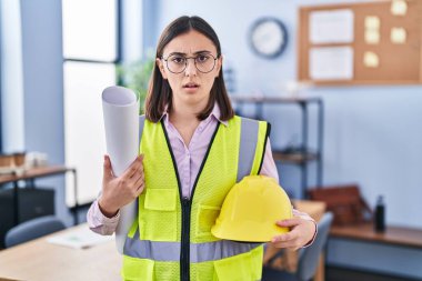 İspanyol mimar kız elinde proje planları tutuyor. Hiçbir şeyden habersiz ve kafası karışık bir ifade. şüphe kavramı. 