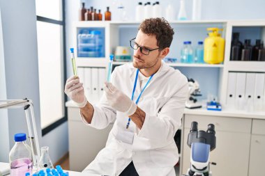 Laboratuvarda test tüpleri tutan genç İspanyol bilim adamı.