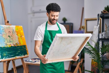 Sanat stüdyosundaki Arap adam kahkahalarla gülüyor.. 