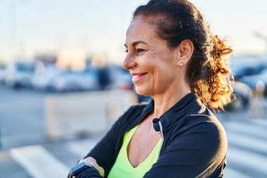 Orta yaşlı İspanyol kadın dışarıda çalışıyor.