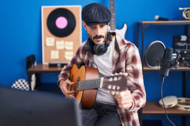 Genç İspanyol müzisyen müzik stüdyosunda klasik gitar çalıyor.