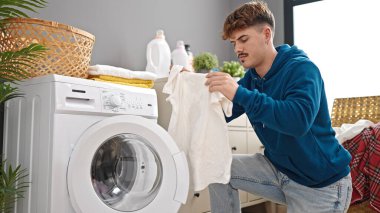 Çamaşırhanede çamaşır yıkayan İspanyol genç adam.