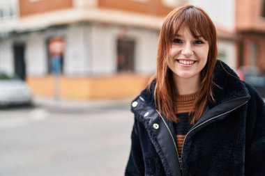 Sokakta kendinden emin gülümseyen genç bir kadın