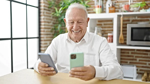 Senior Γκρίζα Μαλλιά Άνθρωπος Χρησιμοποιώντας Smartphones Κάθεται Στο Τραπέζι Στην — Φωτογραφία Αρχείου