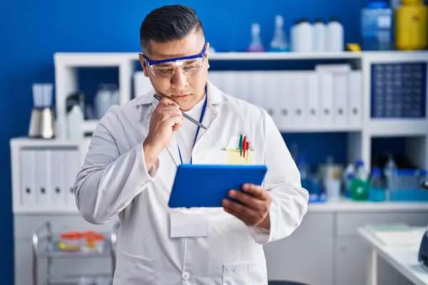 Young Latin Man Scientist Using Touchpad Doubt Expression Laboratory — Stock Photo, Image