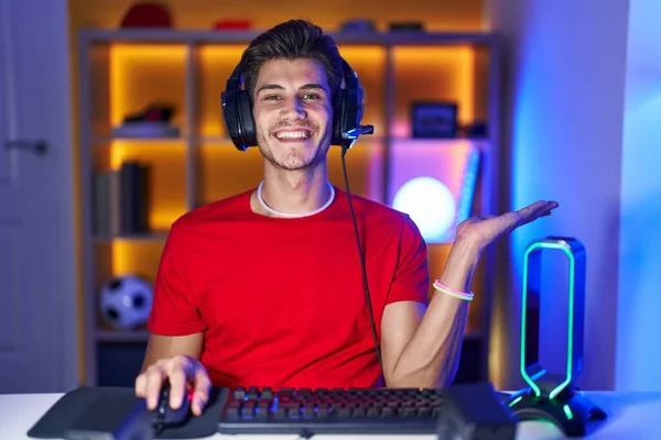 Jonge Spaanse Man Die Videospelletjes Speelt Glimlachend Vrolijke Presentatie Wijzend — Stockfoto