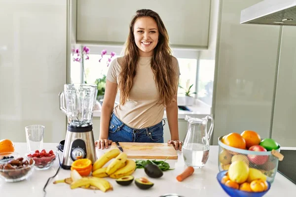 年轻美丽的惊慌失措的女人在厨房用搅拌机准备蔬菜冰沙 — 图库照片