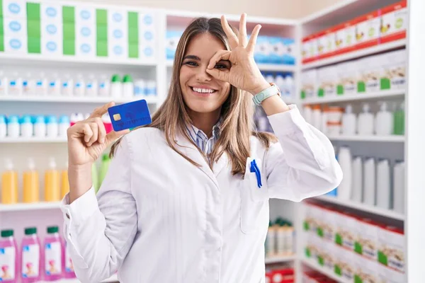 Mujer Joven Hispana Trabajando Farmacia Sosteniendo Tarjeta Crédito Sonriendo Feliz —  Fotos de Stock