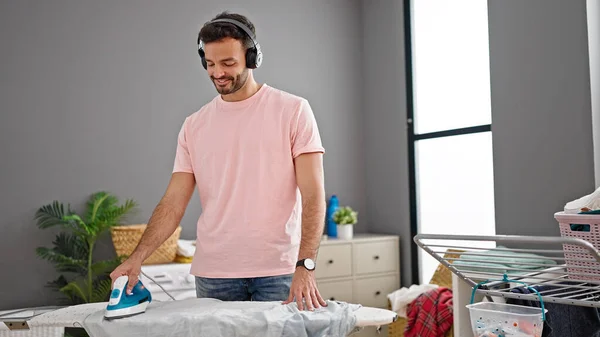 Young Hispanic Man Listening Music Ironing Clothes Laundry Room — Foto de Stock