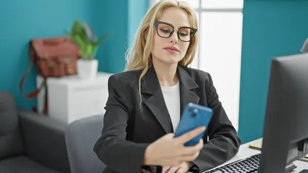Young blonde woman business worker make selfie by smartphone working at the office