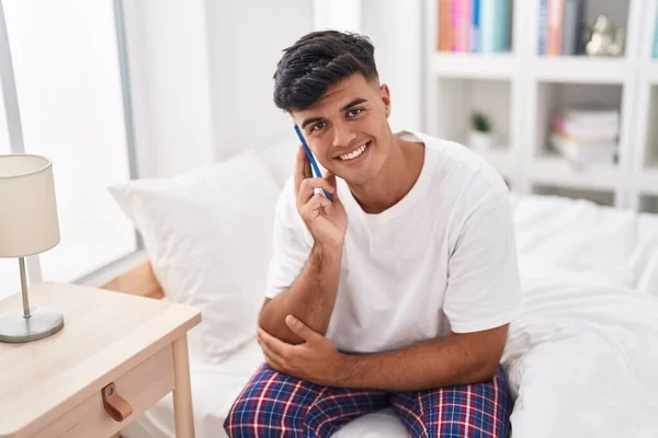 Молодой Латиноамериканец Разговаривает Смартфону Сидя Кровати Спальне — стоковое фото
