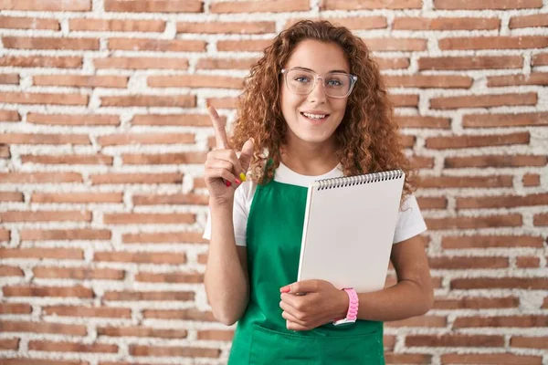 Young Caucasian Woman Holding Art Notebook Smiling Amazed Surprised Pointing — Stock Photo, Image