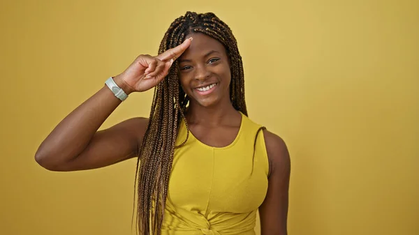 Африканская Американка Улыбается Уверенно Делая Военный Салют Изолированном Желтом Фоне — стоковое фото