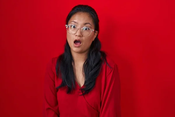 Asyalı Genç Bir Kadın Kırmızı Arka Planda Duruyor Şok Olmuş — Stok fotoğraf