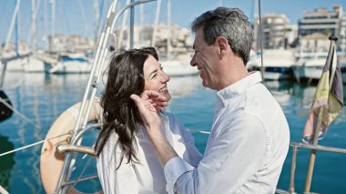 Kıdemli erkek ve kadın çift gülümsüyor teknede birlikte duruyorlar.