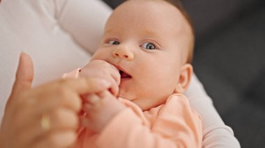 Anne ve kızı evde el ele tutuşuyorlar.