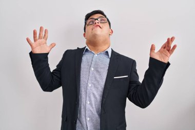 Down sendromlu genç İspanyol adam iş stili giyinmiş deli gibi bağırıyor ve agresif bir ifade ve kollarla bağırıyor. hüsran kavramı. 