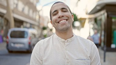 Young hispanic man smiling confident at street