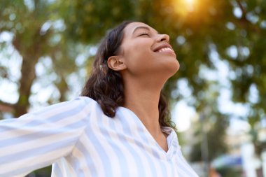 Young african american woman breathing with closed eyes at park