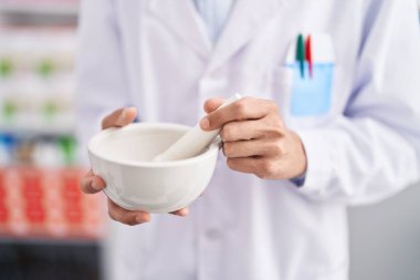 Young hispanic man pharmacist working at pharmacy