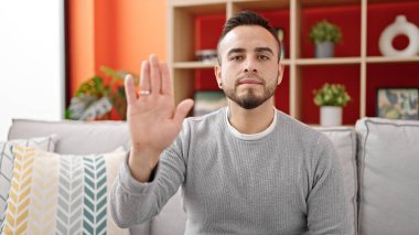 İspanyol adam evde el hareketlerini durduruyor.