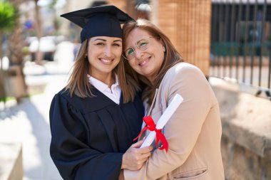 Mother and daughter hugging each other celebrating graduation at university