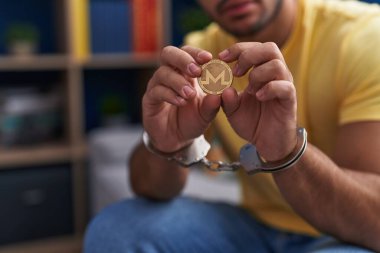 Genç İspanyol suçlu Monero kripto paralarını tutuyor. Evde kelepçe takıyor.