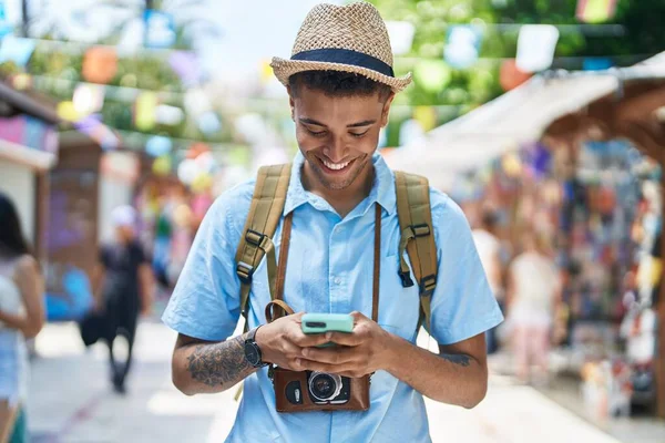 African american man tourist smiling confident using smartphone at street market