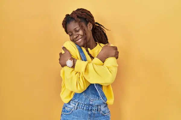 Sarı Arka Planda Dikilen Afrikalı Kadın Kendine Sarılıyor Mutlu Pozitif — Stok fotoğraf