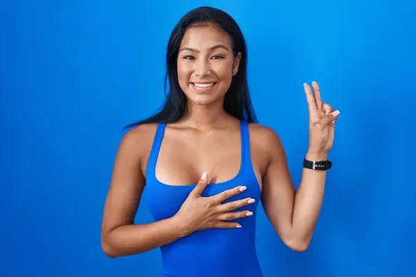 Hispanic Woman Standing Blue Background Smiling Swearing Hand Chest Fingers — Stock Photo, Image