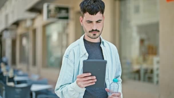 Νεαρός Ισπανόφωνος Χαμογελώντας Σίγουρος Χρησιμοποιώντας Touchpad Κρατώντας Μπουκάλι Νερό Στη — Αρχείο Βίντεο