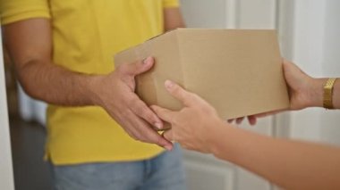 Genç Latin adam evde paket alıyor.