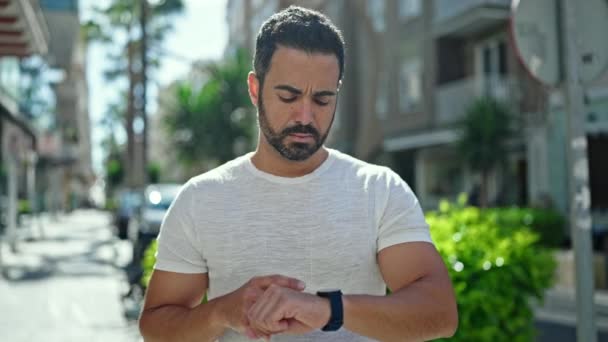 Jovem Hispânico Homem Com Rosto Sério Olhando Relógio Rua — Vídeo de Stock