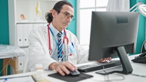 Lekarz Średnim Wieku Korzystający Komputera Klinice — Wideo stockowe
