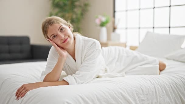 Young Blonde Woman Wearing Bathrobe Lying Bed Smiling Bedroom — Stock Video