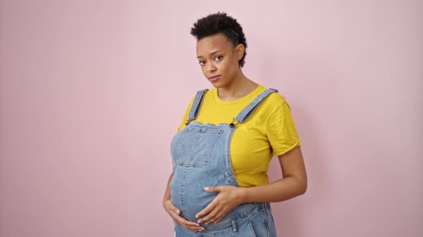Ung Gravid Kvinna Ler Säker Pekar Magen Över Isolerade Rosa — Stockvideo