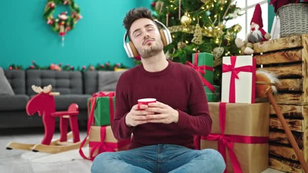 Młody Latynos Słuchający Muzyki Pijący Kawę Świętujący Boże Narodzenie Domu — Wideo stockowe