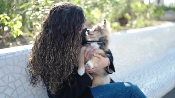 Молодая Латиноамериканка Собакой Уверенно Улыбающаяся Сидя Скамейке Парке — стоковое видео